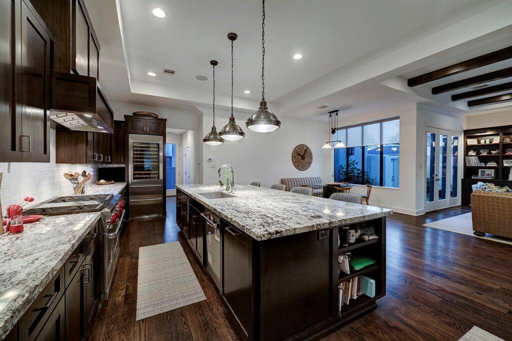 Large bar area with sink, icemaker with sonic ice, great counter space, upper cabinetry with glass fronts and lower storage and under counter lighting. Access from dining area and kitchen.