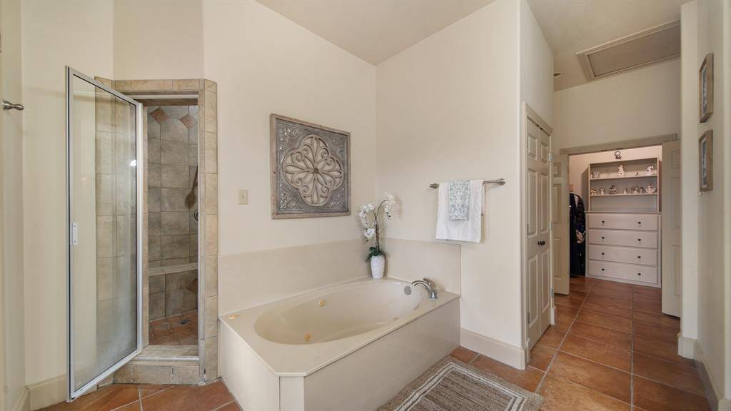 A view of the jetted tub and entry to the separate tiled shower.