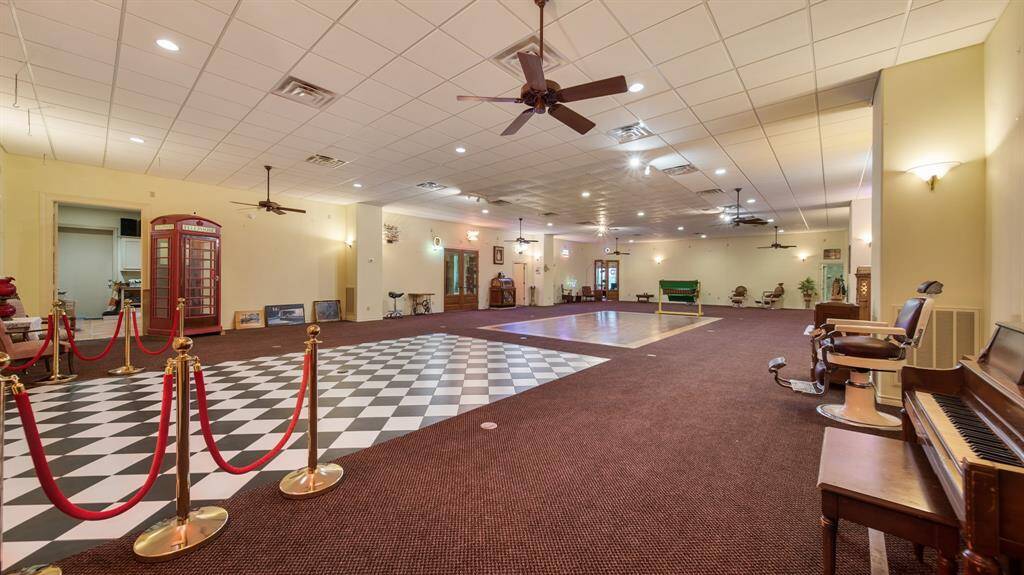 You are looking at a spacious 74x40, multi-purpose room with high ceilings, featuring a checkered floor area, offering a unique blend of vintage charm and versatility for various activities or functions.