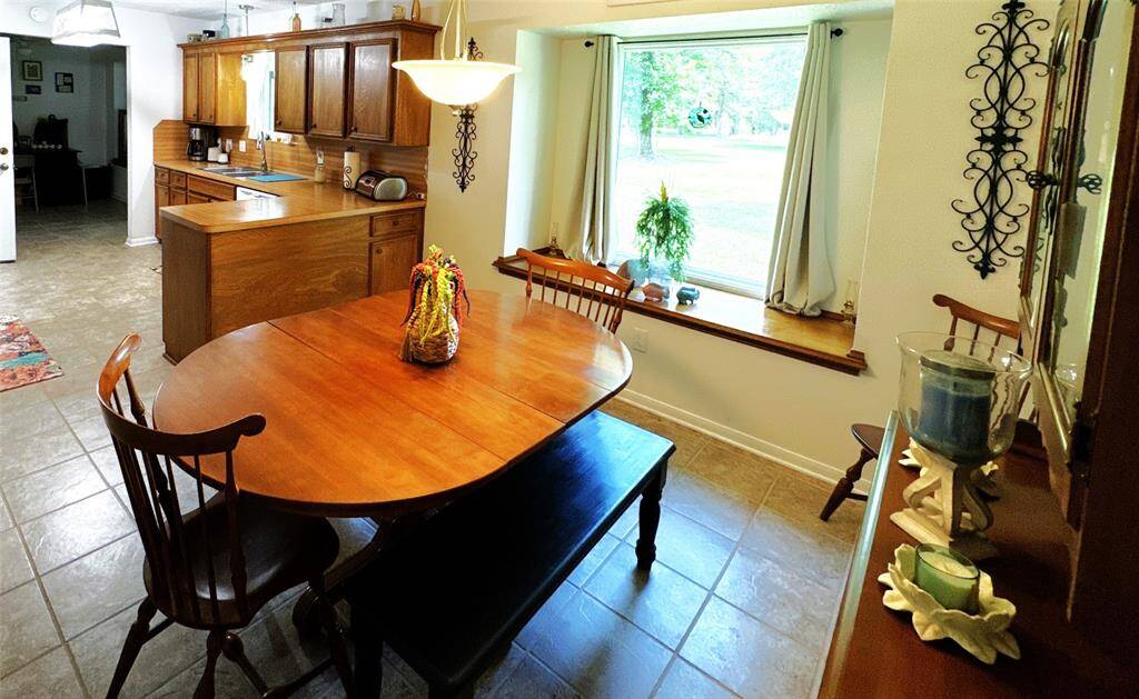 Bright dining area adjacent to the kitchen, featuring a large bay window with backyard views.
