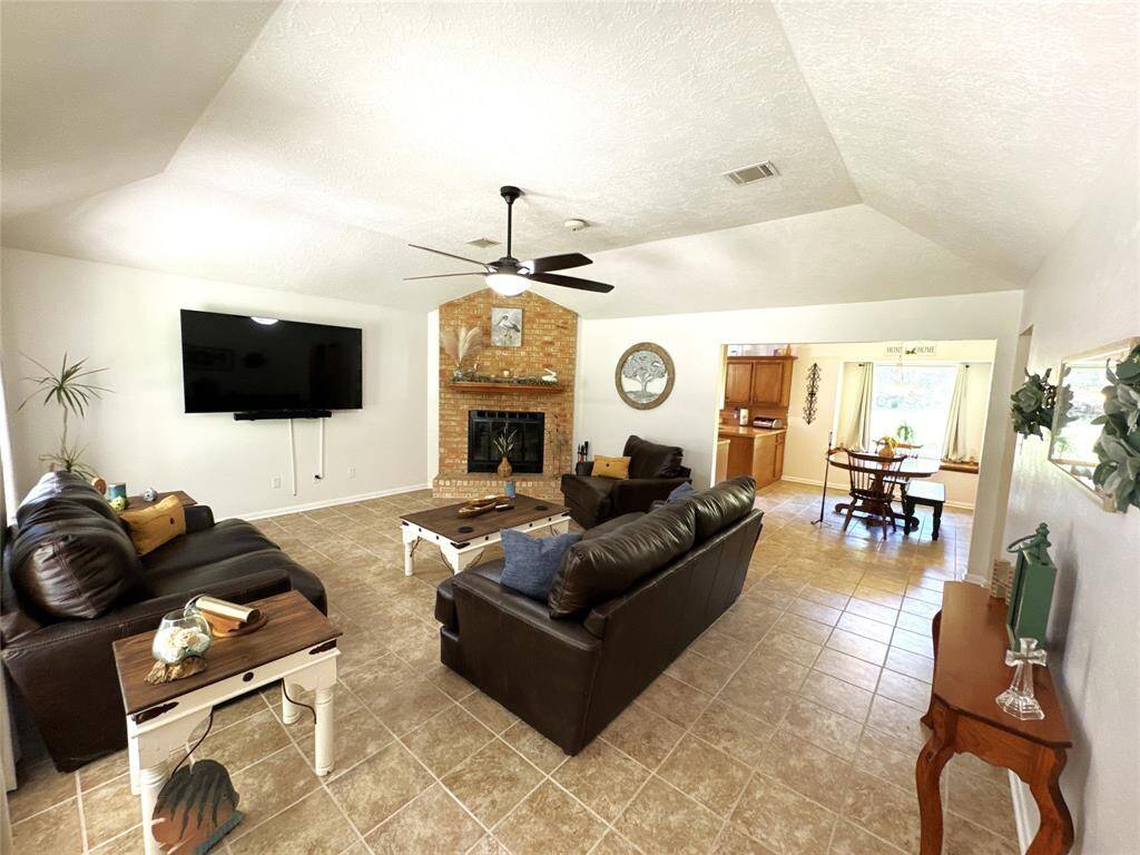 Welcoming living room with cozy seating and a charming fireplace, easily viewed from the front entrance. All furniture items in this room are included with the sale.