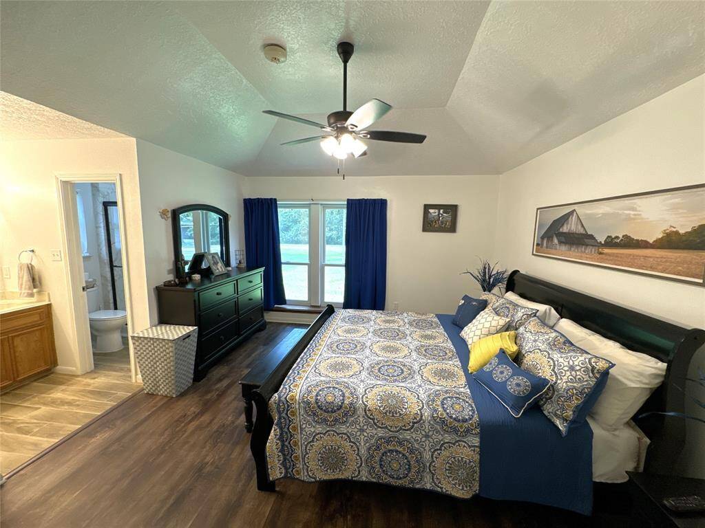 Elegant primary bedroom with ensuite bath, featuring all included furniture.