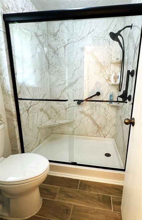 Remodeled shower with elegant tile and a convenient corner bench.