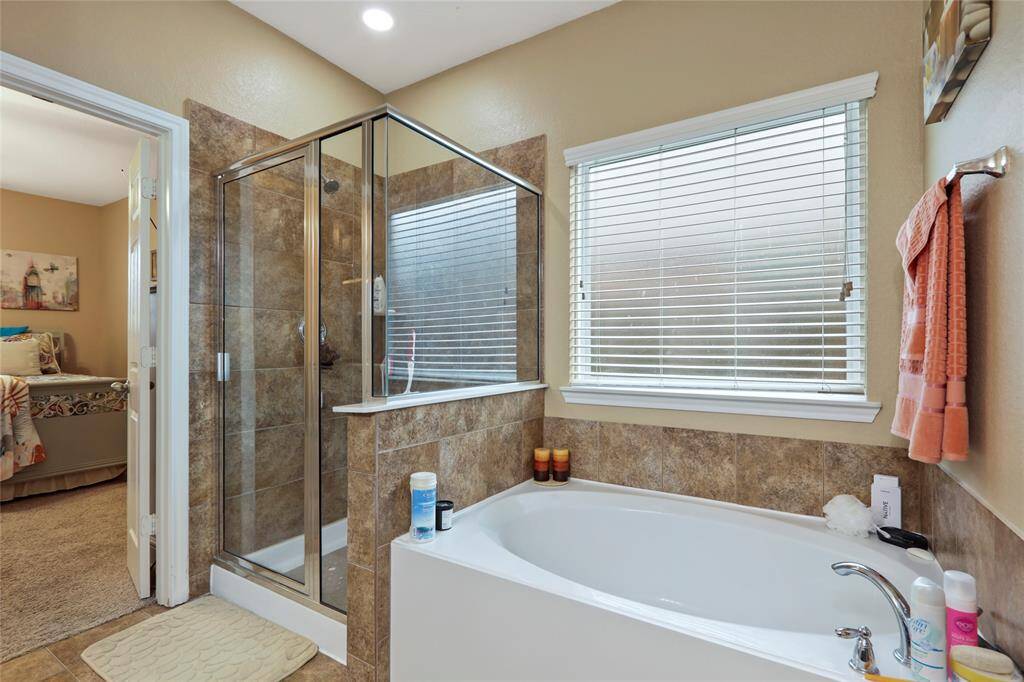 Primary bath with walk-in shower and separate soaking tub.