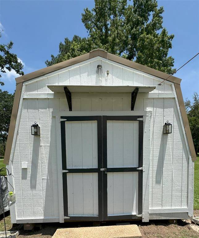 Charming workshop nestled behind the carport, perfect for projects and storage.
