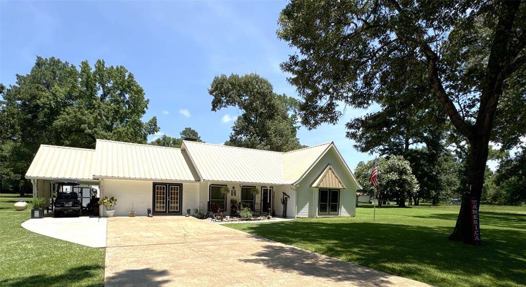 Serene front view with lush shade trees enhancing the home's charm.