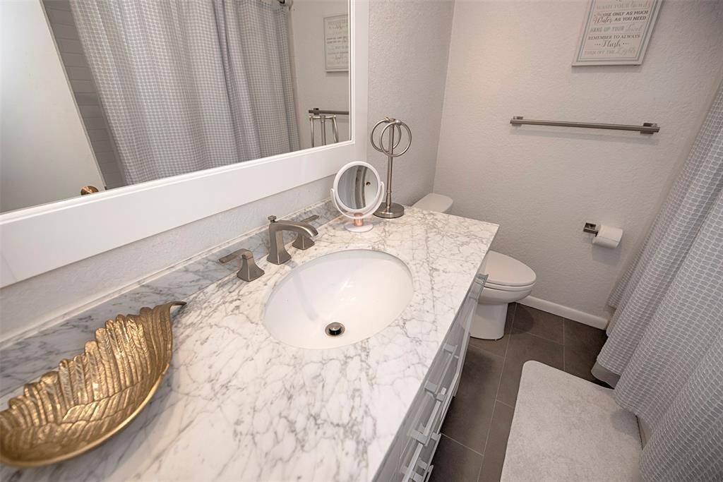 Bedroom #3 en suite private bathroom with large vanity. Bathroom also features a combo bath and shower.