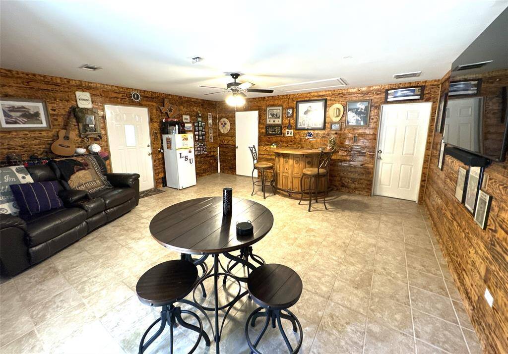 Spacious converted garage with included furnishings and a mounted flat screen TV, perfect for entertainment.