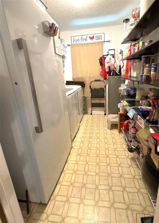 Spacious laundry room accommodates a washer, dryer, and includes a large freezer that stays with the home.