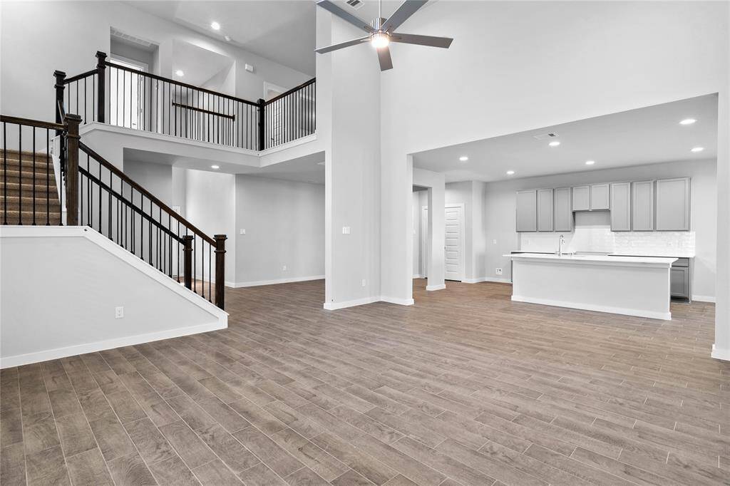 Additional grand view from the Family Room showcasing the gorgeous stairway that leads to the second floor and the spacious kitchen.