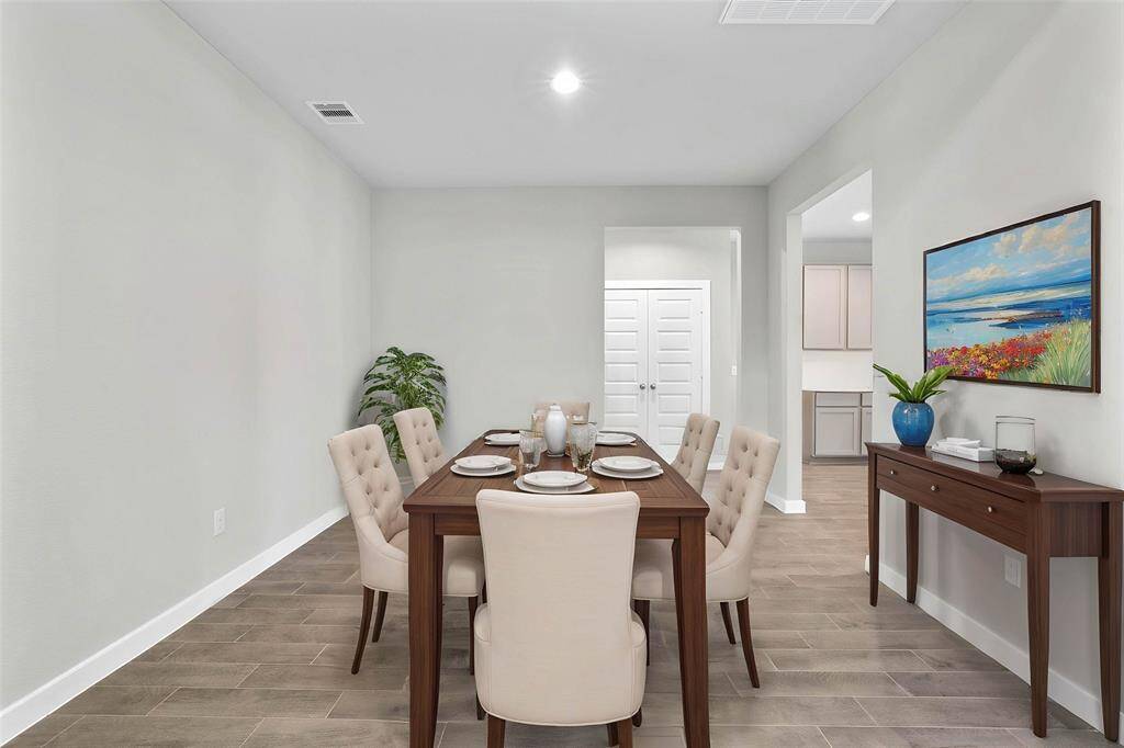 Make memories gathered around the table with your family and friends! This dining room features high ceilings, recessed lighting, custom paint, and gorgeous wood look tile flooring.