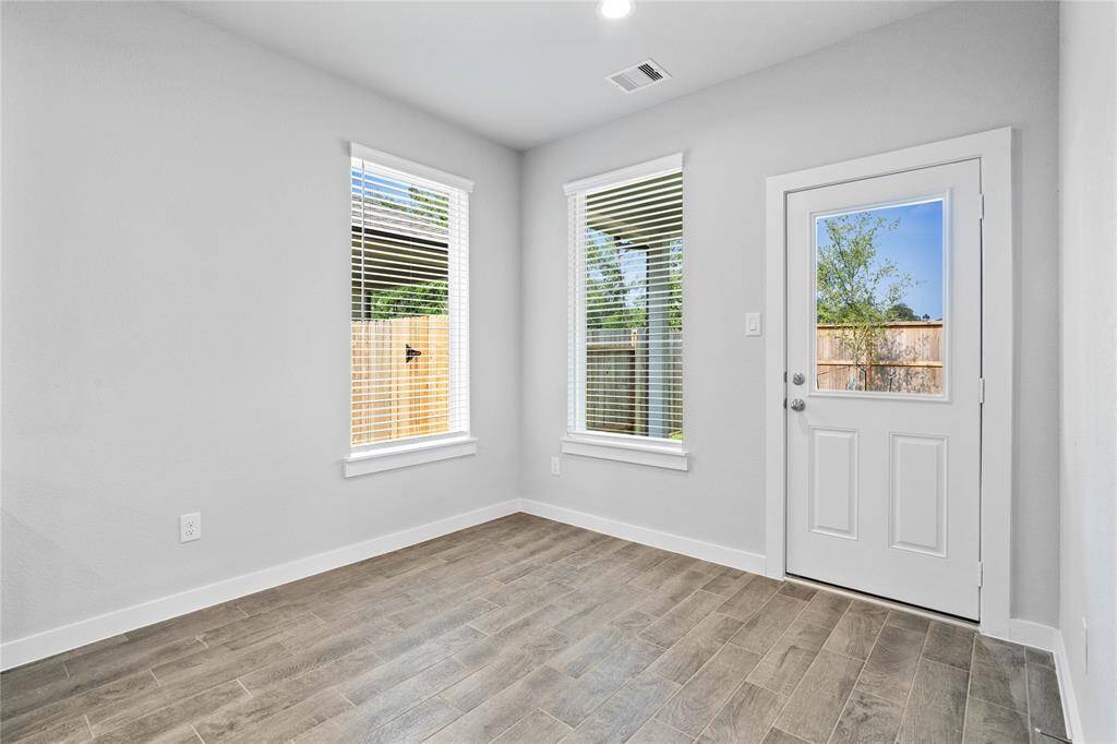 Gather together in the breakfast area! Featuring windows with blinds, custom paint, wood look tile flooring, and access door to back yard!
