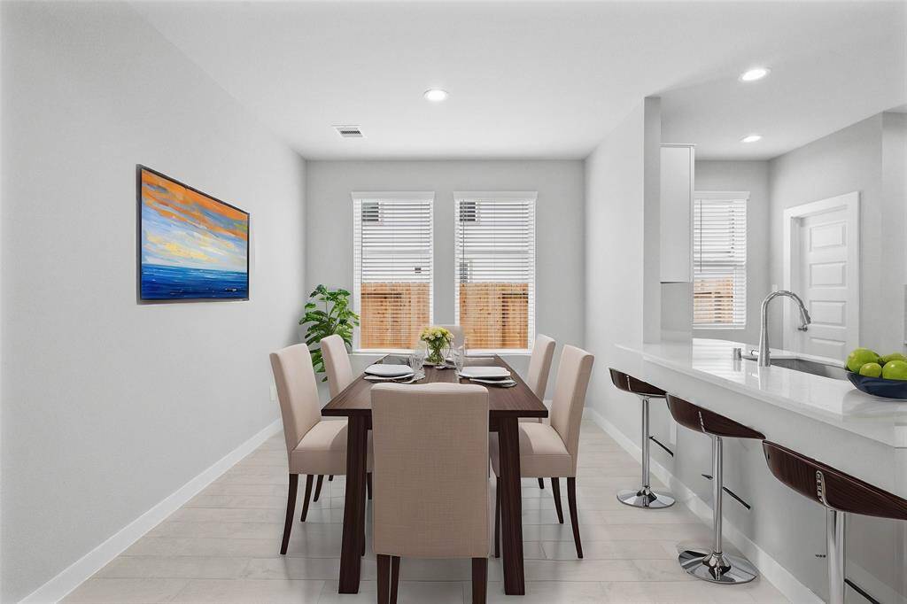 Make memories gathered around the table with your family and friends! This dining room features high ceilings, wood look tile flooring, recessed lighting, and large windows with blinds!