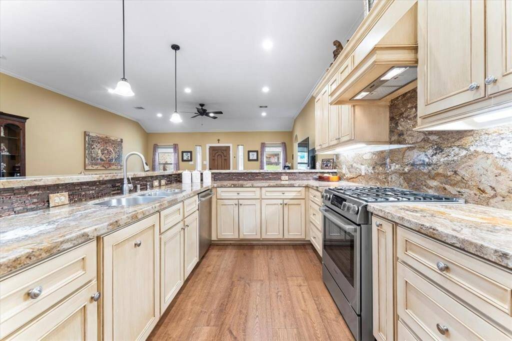The kitchen boasts BOSCH appliances, a gas stove, spice racks, a convenient eat-in breakfast bar and lots of cabinets.