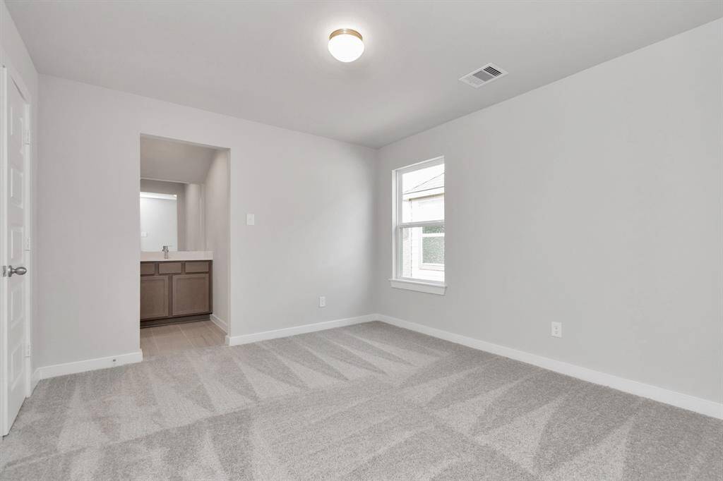 Secondary bedroom features plush carpet, custom paint, large window with privacy blinds and access to the Jack and Jill bath. Sample photo of completed home with similar floor plan. Actual colors and selections may vary.