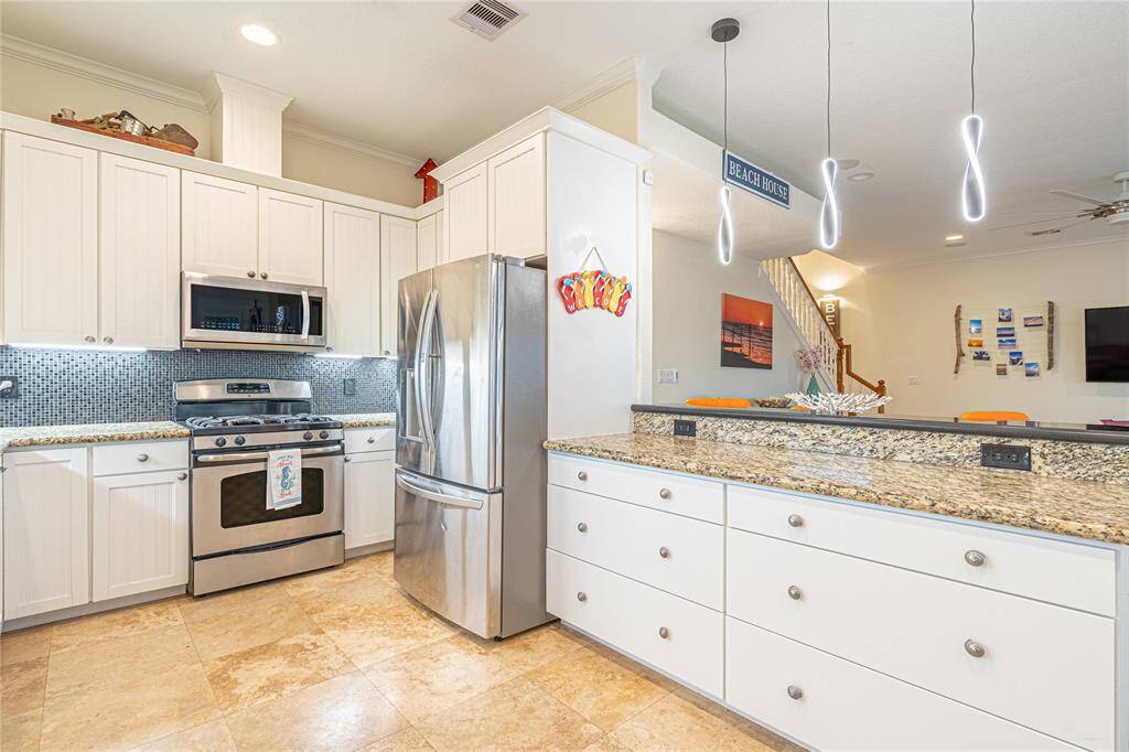 Relax or dine al fresco on the shaded lower-level deck with easy access to the yard and beach beyond.