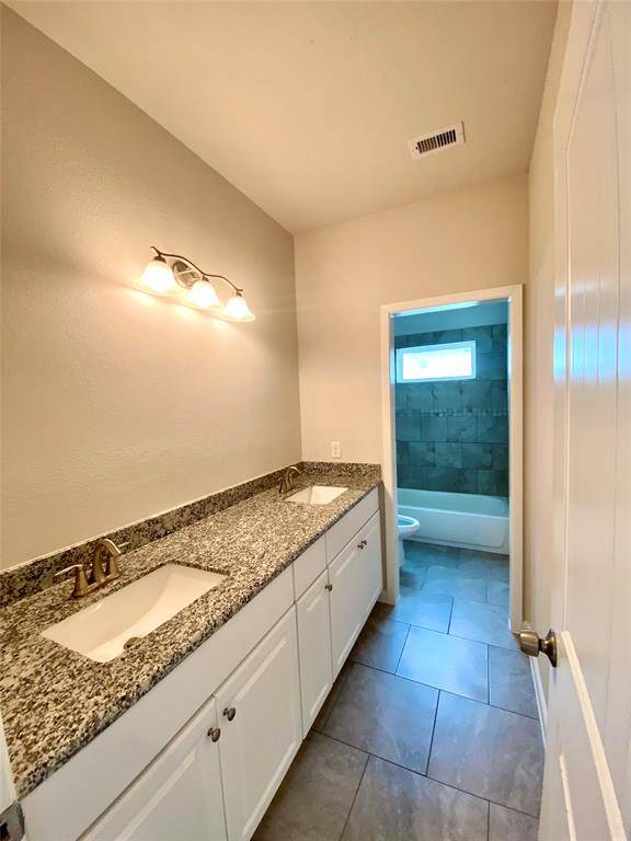 Upstairs bath with double sinks and granite countertops.