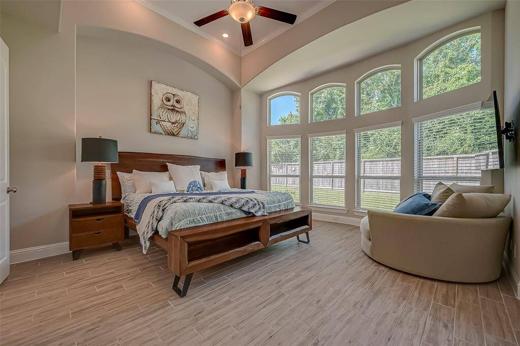 Large windows frame views of the surrounding landscape, allowing natural light to fill the room and create a bright, airy atmosphere. Soft, neutral tones on the walls and flooring enhance the sense of  style & sophistication.