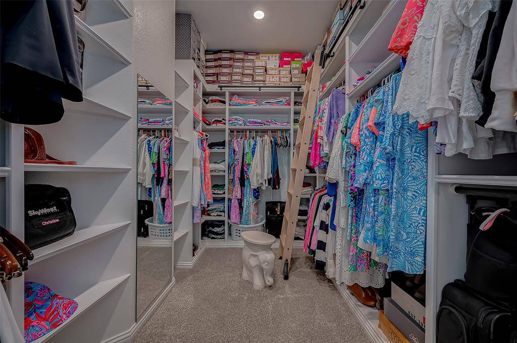 Straight out of a designer magazine this primary closet is sophistication and style. Spacious climate controlled with custom shelving and ladder to reach those high shelves. This high-end closet is more than just storage; it’s a bespoke dressing room designed to elevate your daily routine and reflect your sophisticated taste.