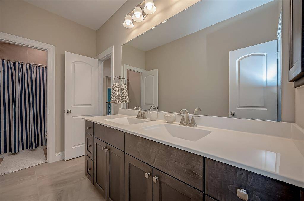 This upstairs bath offers two vanities, J-Kraft cabinets and cultured marble countertops.