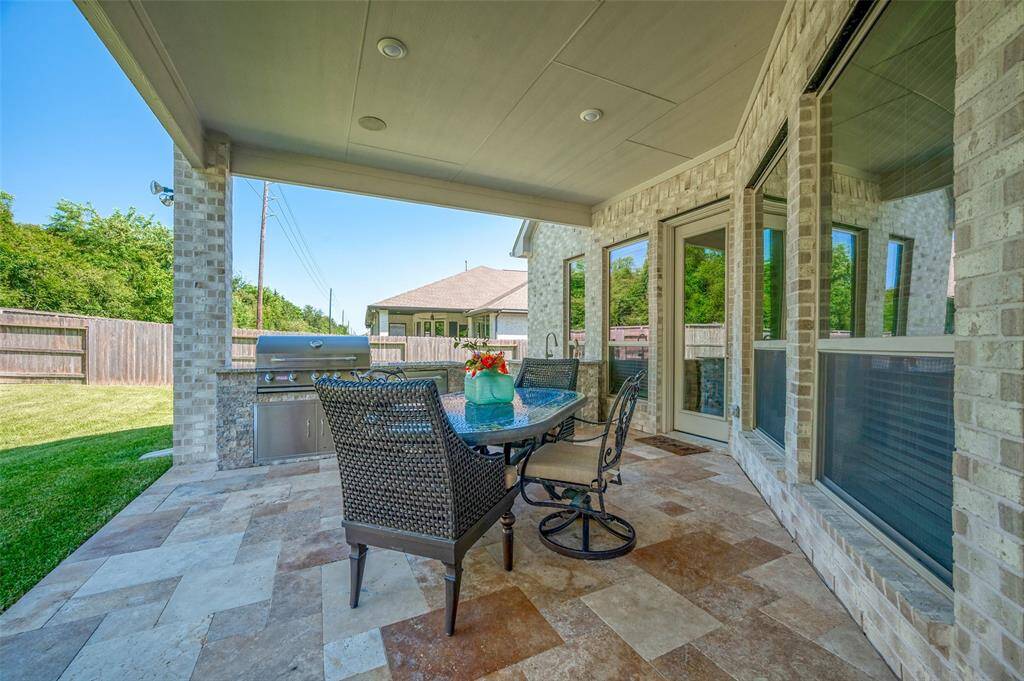 This covered patio with outdoor kitchen is the perfect place to have BBQ's and watch some football with your outdoor TV.