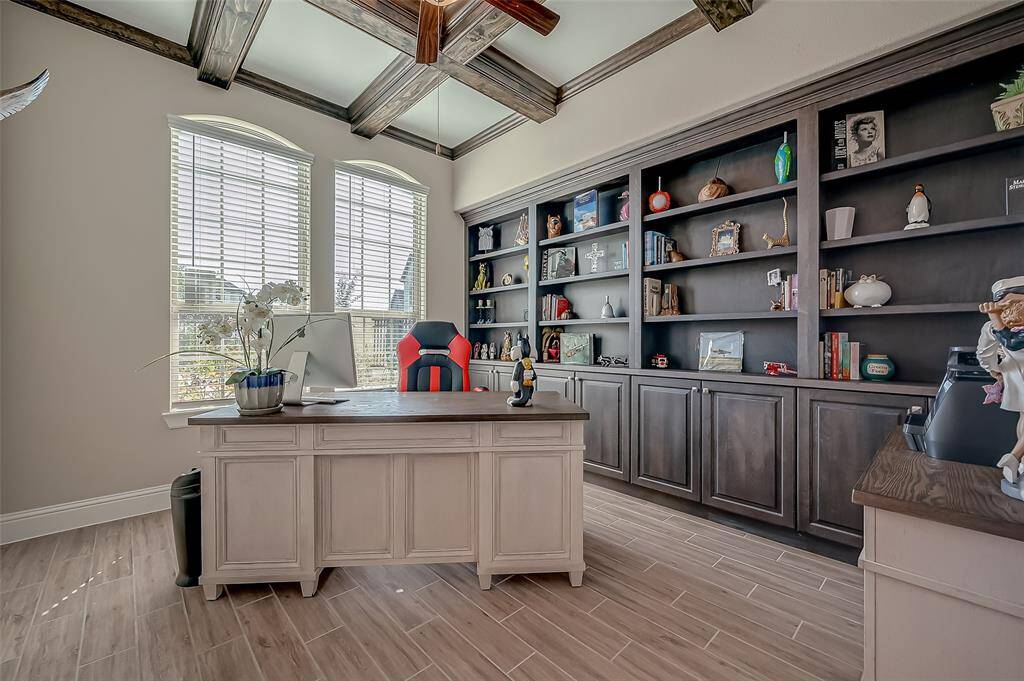Step into a home office that perfectly blends traditional charm with modern functionality, featuring striking wood beams that add a touch of rustic elegance to your workspace.
