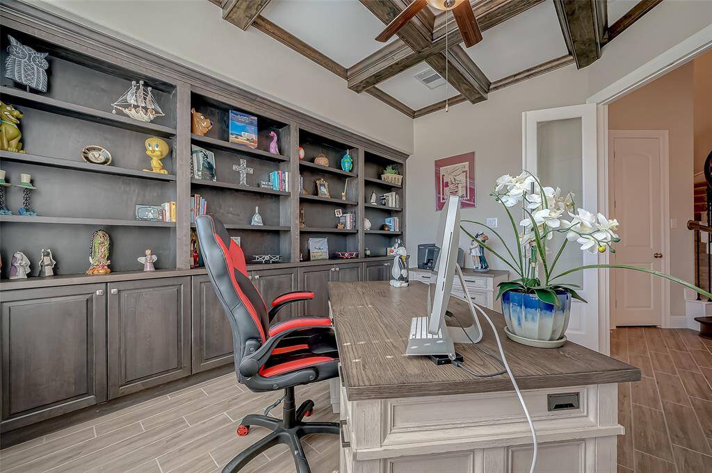 This home office has etched-glass french doors, wall to wall custom bookshelves and an abundance of cabinets for storage.