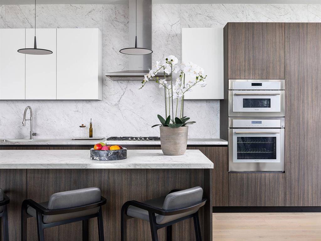 The gourmet kitchen boasts custom PEDINI cabinetry and top-of-the-line Thermador appliances, perfect for the culinary enthusiasts. *Model photo of unit