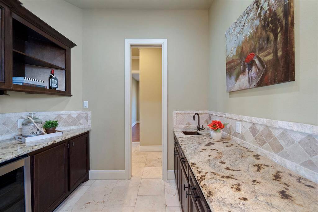 Seamlessly transition from the elegant butler's pantry to the heart of the home, the kitchen, through a connecting hallway.