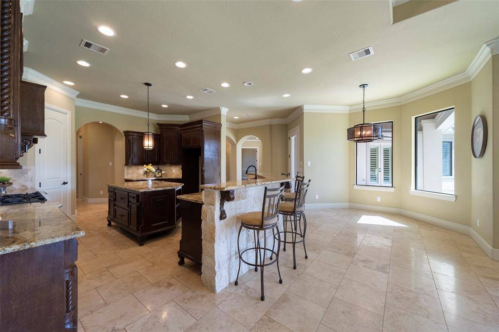 Enjoy ample and stylish breakfast bar seating in this inviting kitchen space.