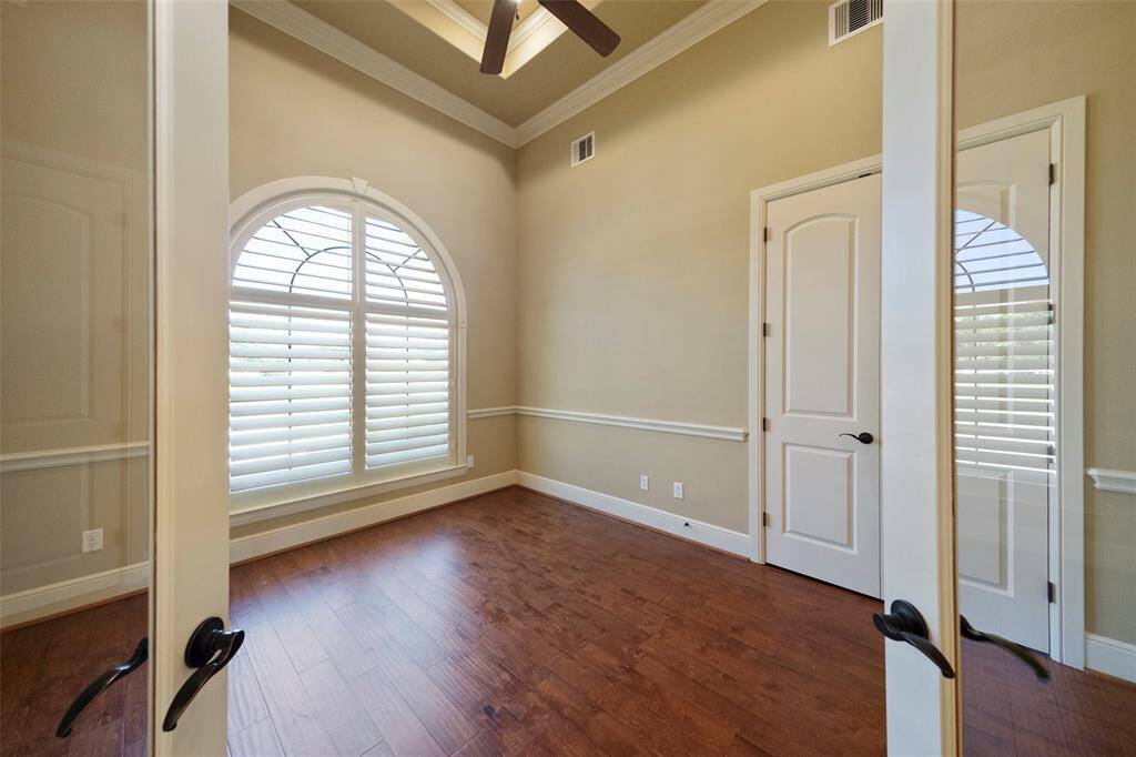 Discover this refined home office, boasting chic glass French doors and bathed in abundant natural light.