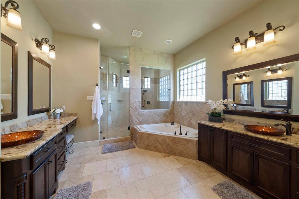 Indulge in luxury with a soothing jetted tub and expansive custom walk-in shower.