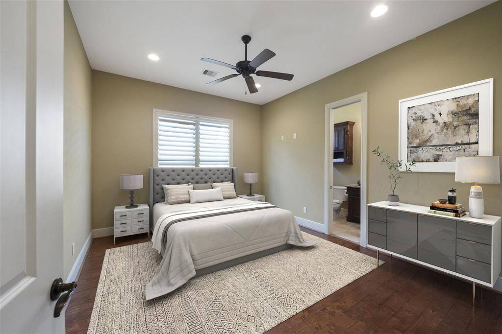 This is a well-appointed, bedroom featuring neutral tones, hardwood floors, and ample natural light. It includes a stylish en suite bathroom for convenience.