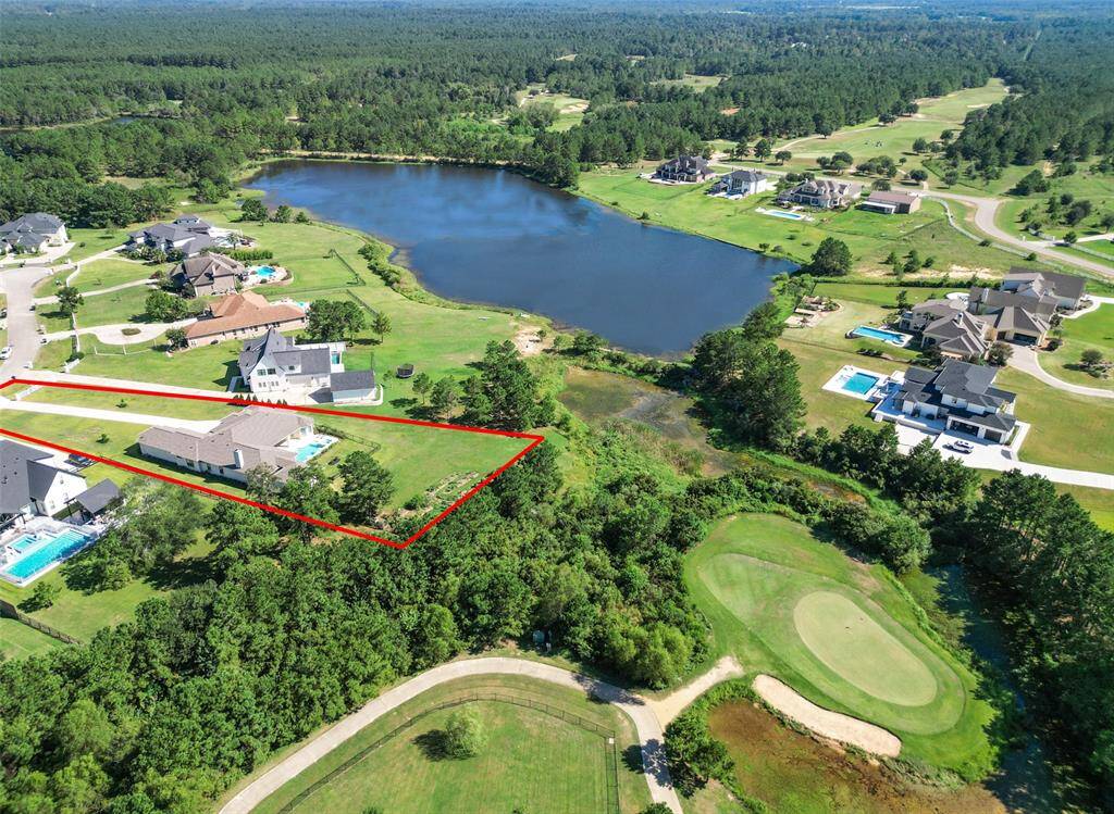 This aerial photo showcases a spacious property marked by a red outline, offering a serene lake view and proximity to a golf course. The neighborhood features well-appointed homes with generous yards and amenities like swimming pools, epitomizing upscale suburban living.