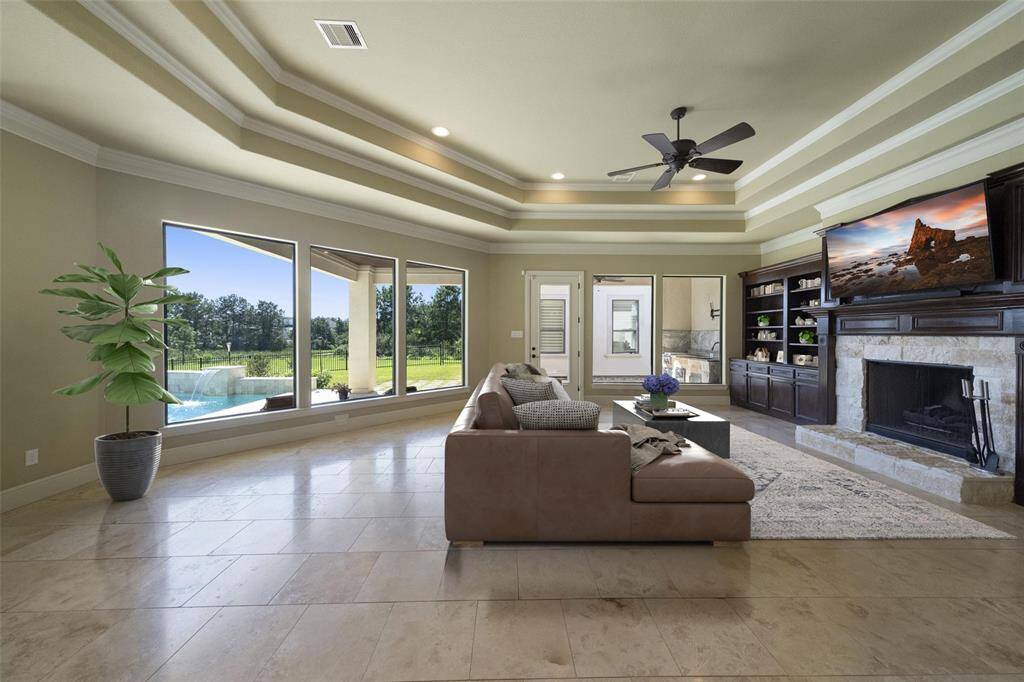 Bask in the natural light of the generous open-concept living space, complete with a cozy wood-burning fireplace and elegant custom built-ins.