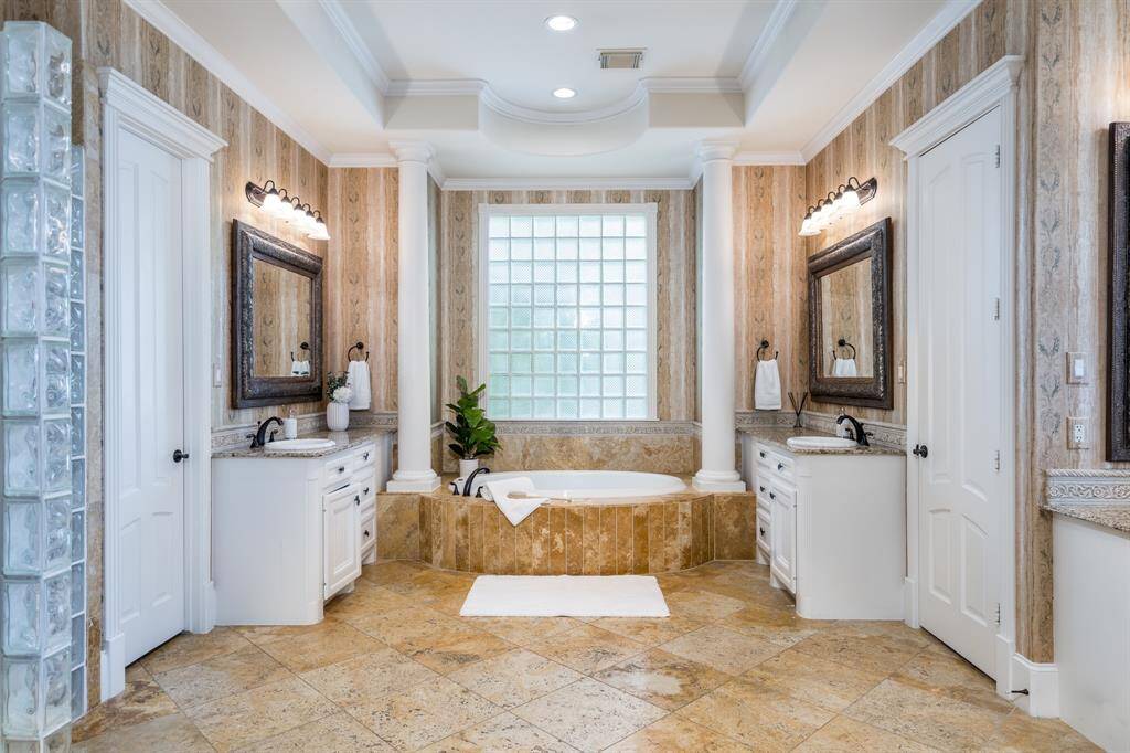 Spa bath offers travertine floors, two vanities, walk-in shower, and two walk-in closets.