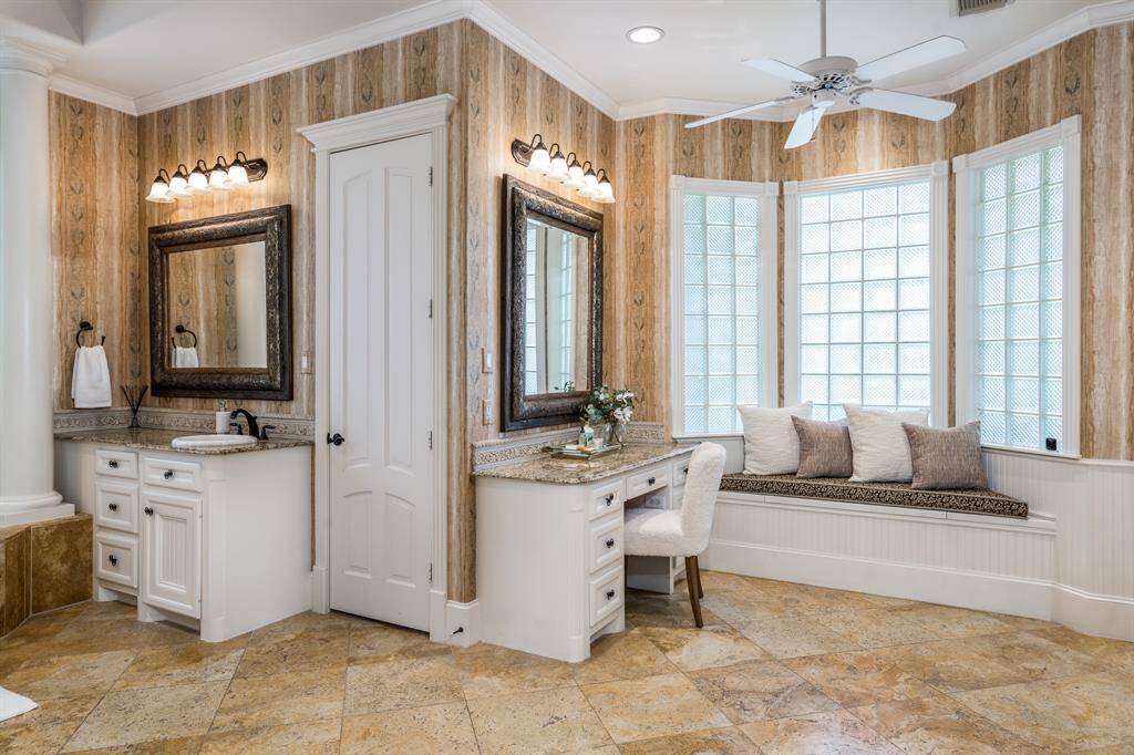 Luxurious dressing area with makeup vanity and granite counters.