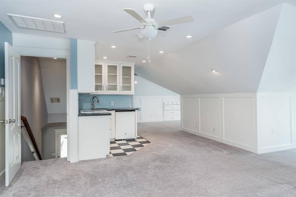 Separate stairs lead to full quarters with a kitchenette including a cooktop, small fridge, and sink.