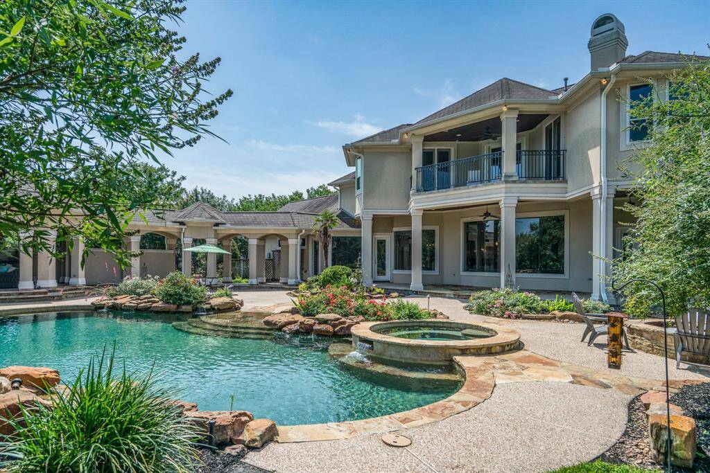 Pebble Tech pool has a sloped flagstone entry, hot tub, and multiple rock waterfalls.
