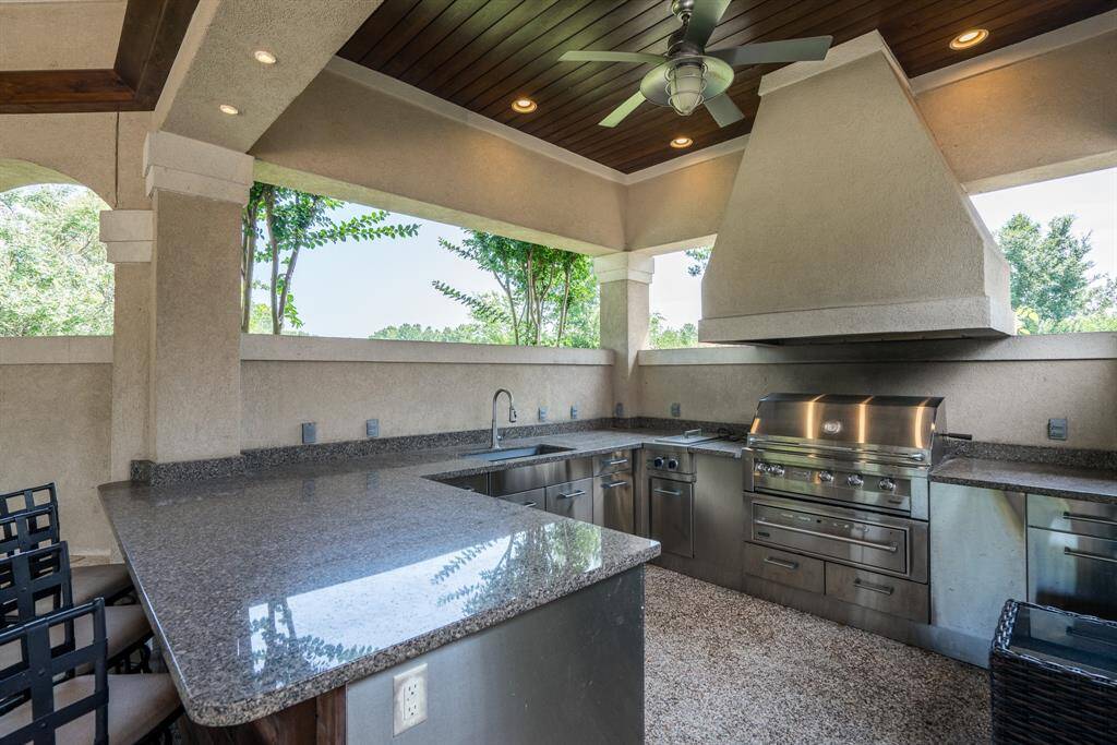 Large granite outdoor kitchen with stainless applainces and large venthood for the Grill Master.