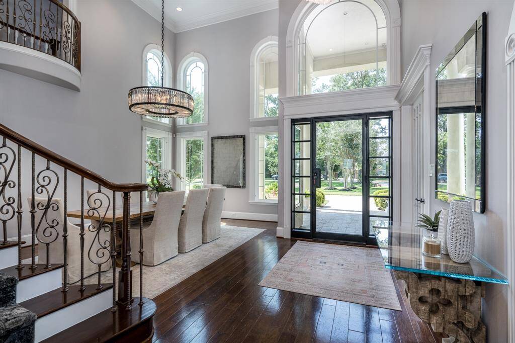 Stunning entry with soaring ceiling, wrought iron framed door, and Restoration Hardware chandeliers.
