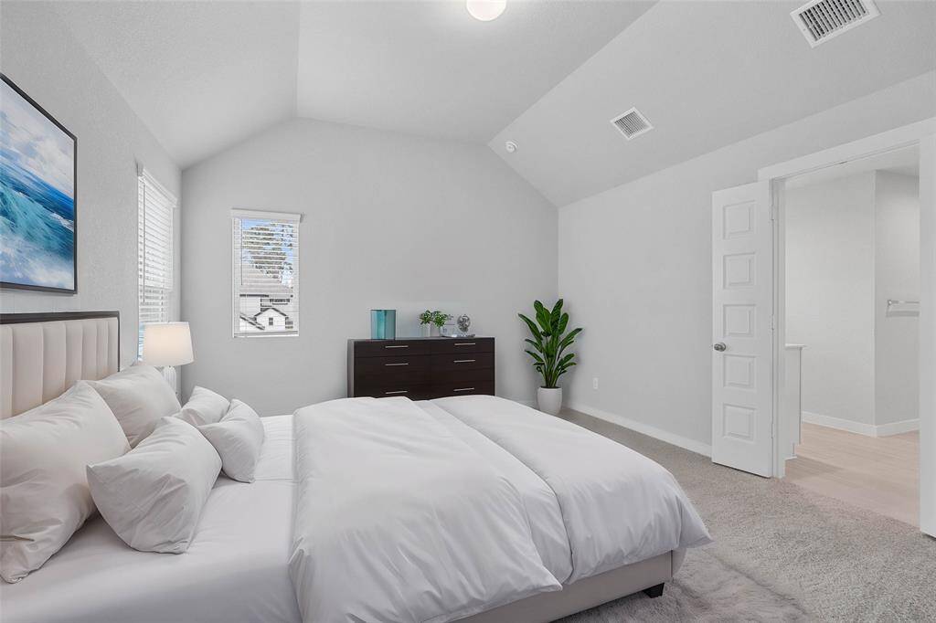 What a wonderful place to come home to, this stunning primary suite greets you with plush carpet, warm custom paint, high ceiling, lovely windows with privacy blinds allowing in natural light brightening up this spacious bedroom.