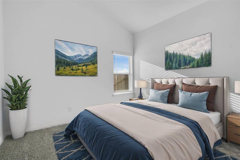 Secondary bedroom features plush carpet, neutral paint, high ceilings, and a large window with privacy blinds. *virtually staged*