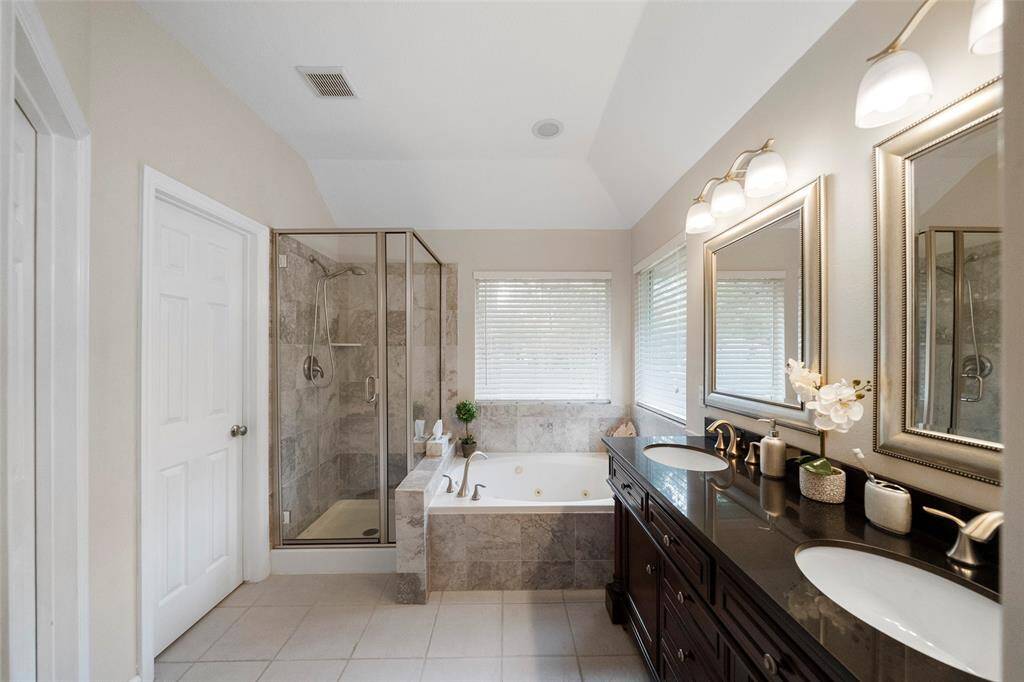 Luxurious spa features double sinks in updated vanity & new tile work in shower and tub.