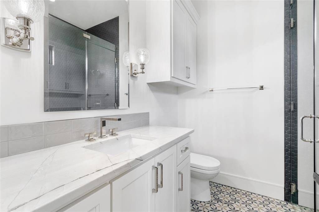 Secondary bath off the downstairs secondary bedroom. Beautiful quartz counters and stylist light fixtures.