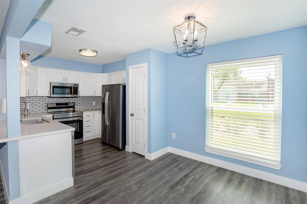 The dining area has a large window that lets the natural light flow through the room.