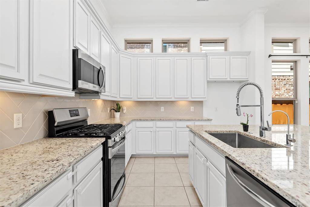 Chef's kitchen with large sink and stainless steel appliances.