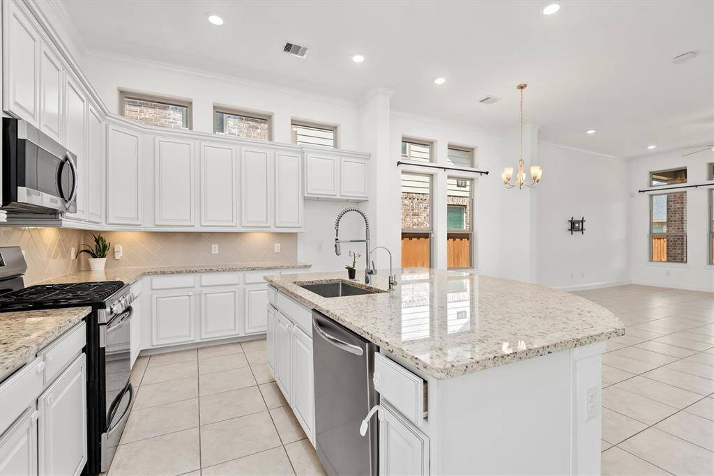 Chef's kitchen with large sink and stainless steel appliances.