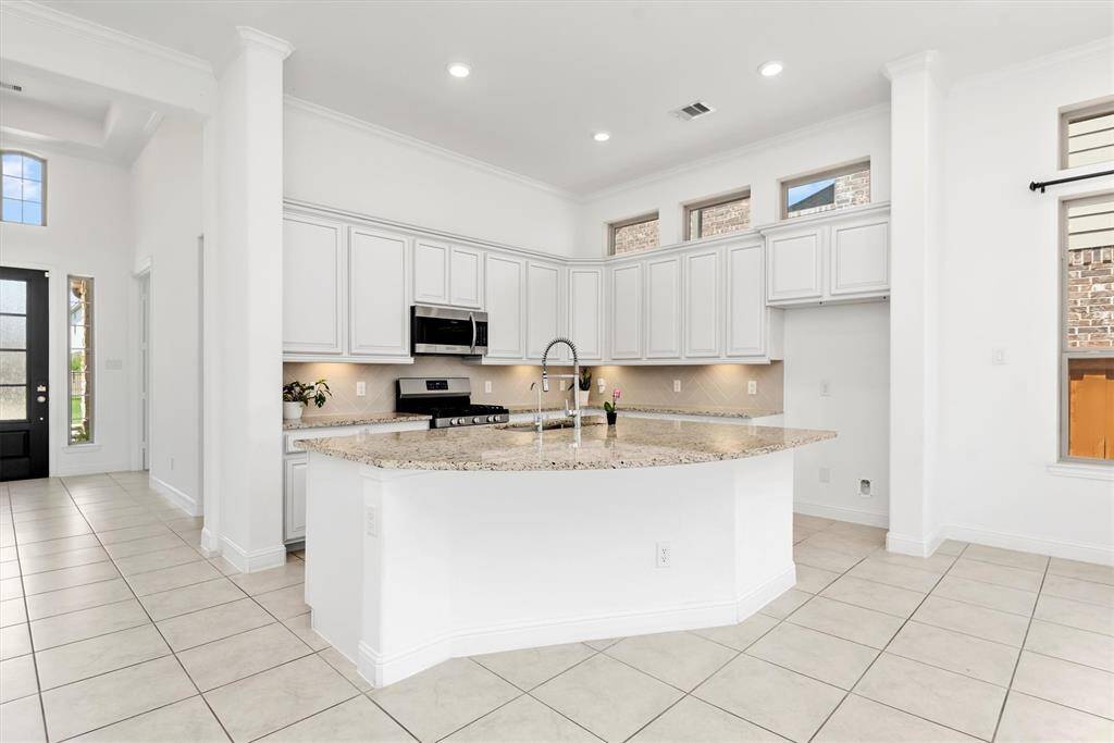 Chef's kitchen with large sink and stainless steel appliances.