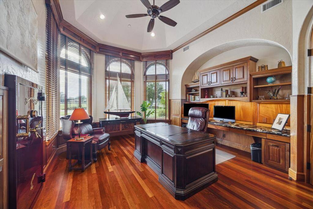 The handsome executive study exudes warmth and sophistication. The study features a built-in desk and cabinetry topped with bullnose marble counters and a groin vault ceiling above. A bay of Palladian windows provides a view into the courtyard and the acreage beyond. A built-in American Security oversized safe holds important documents and valuables. A second built-in desk and safe are also located within the study but in an adjoining annex discreetly out of view.